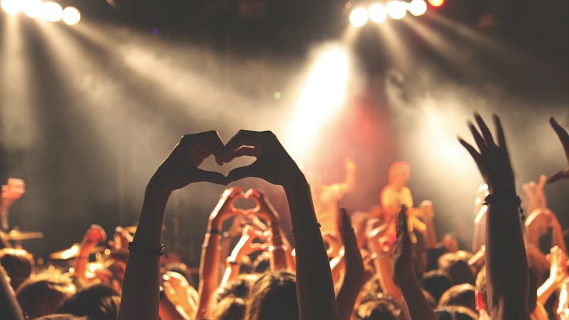Festivaliers dont l'un forme un coeur avec ses doigts